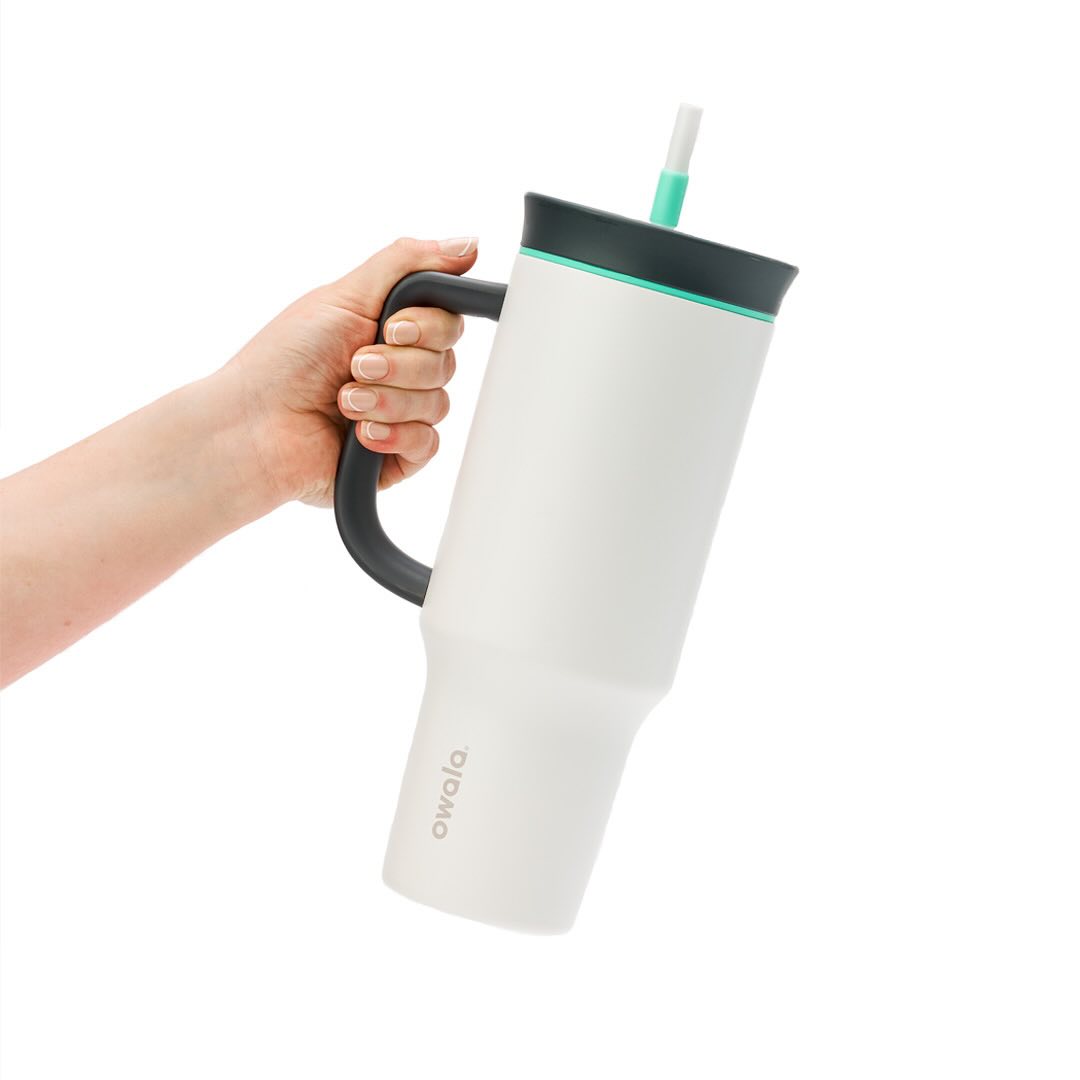 Pessoa segurando o Copo Tumbler Térmico Owala - 1180ml | 40oz com alça e tampa 2 em 1, destacando o design de aço inoxidável.