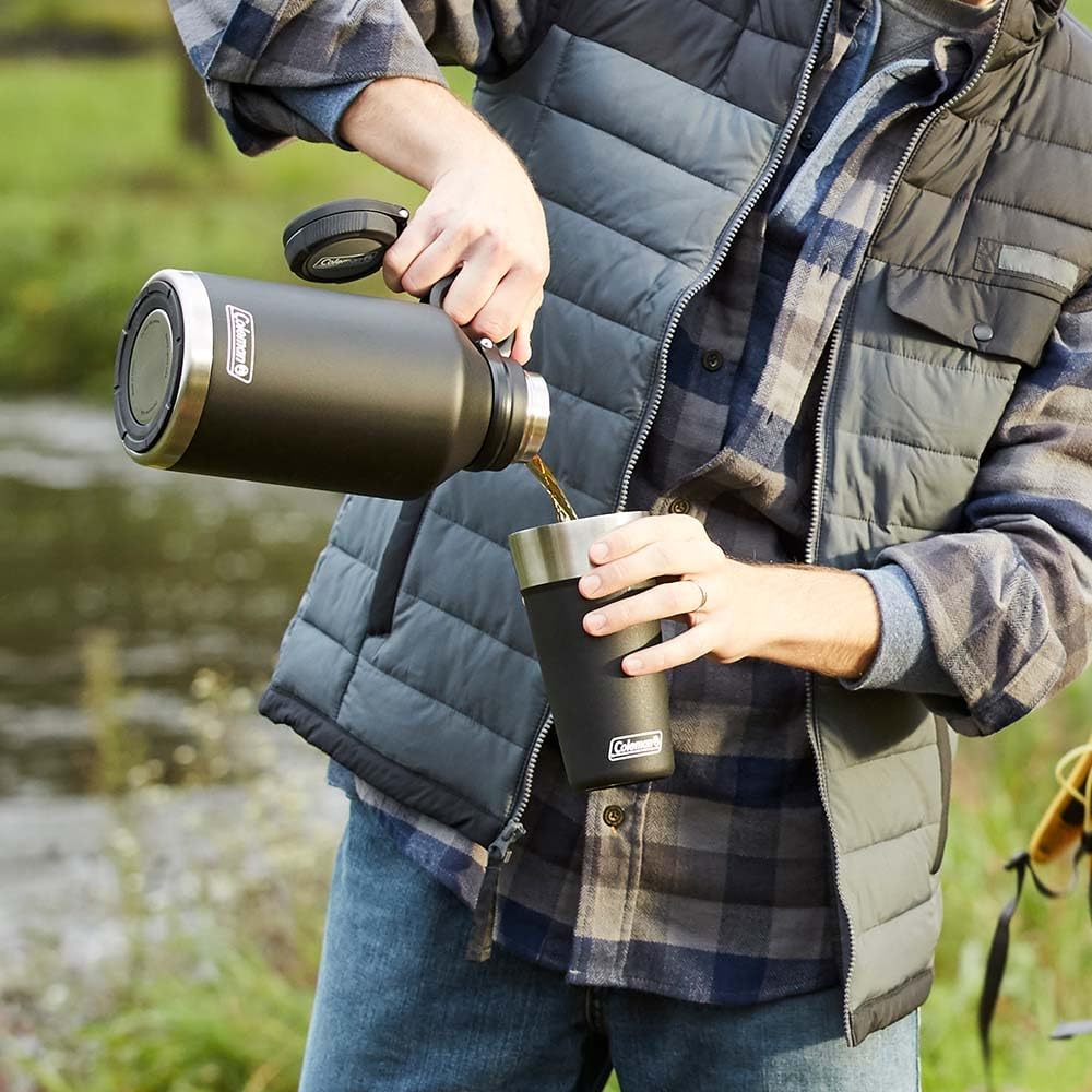 Pessoa usando o Growler 1,9L Preto Coleman em ambiente ao ar livre, ideal para manter bebidas na temperatura ideal.