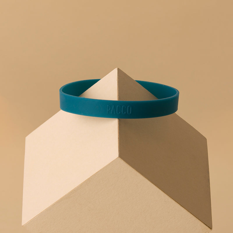 Anel de Silicone PACCO sobre base geométrica, destacando design ergonômico e toque de estilo para garrafas.