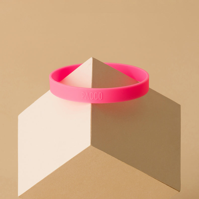 Anel de Silicone PACCO rosa, design ergonômico e decorativo, em exibição sobre um suporte geométrico, destacando estilo e conforto.