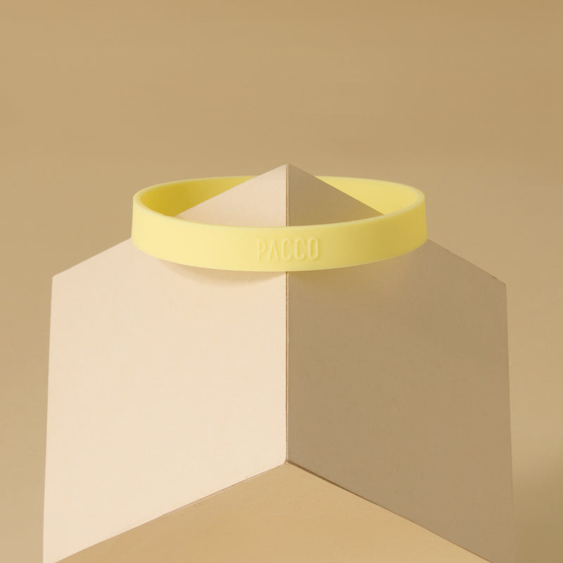 Anel de Silicone PACCO amarelo sobre fundo bege, destacando ergonomia e estilo moderno para garrafas.