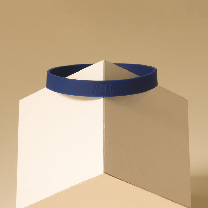 Anel de Silicone PACCO azul em exibição sobre um pedestal geométrico, destacando seu design ergonômico e toque de estilo.