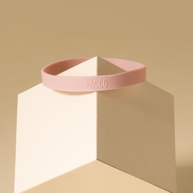 Anel de Silicone PACCO em rosa sobre um pedestal geométrico