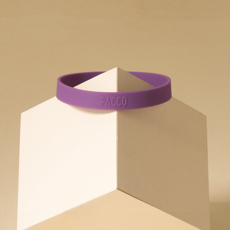 Anel de Silicone PACCO roxo, ergonômico, para estilo e conforto ao abrir garrafas, em exibição sobre um cubo branco.