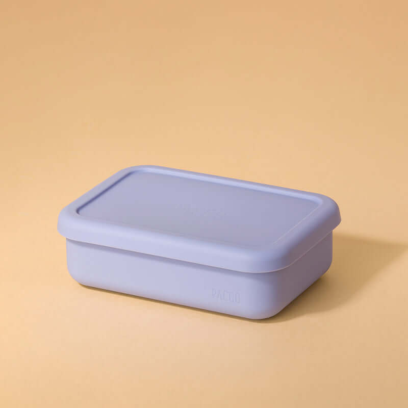 Lunch Box em Silicone - PACCO roxa em fundo bege, ideal para refeições organizadas e portáteis, feita de silicone ecológico, compacta e dobrável.