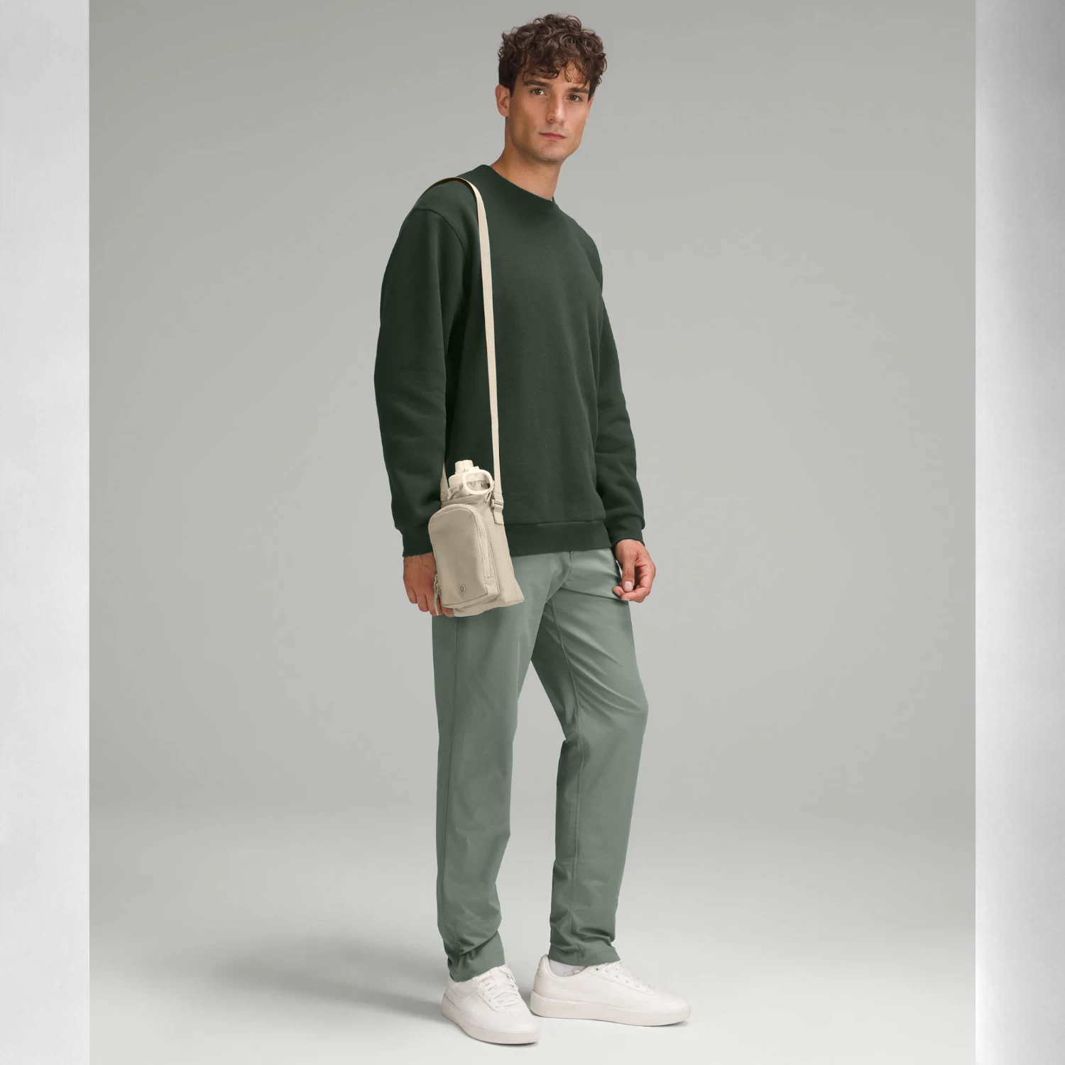 Homem usando Bolsa para Garrafa Térmica - Cross Bottle Lululemon, ideal para transporte de garrafas, celular e chaves com mãos livres.