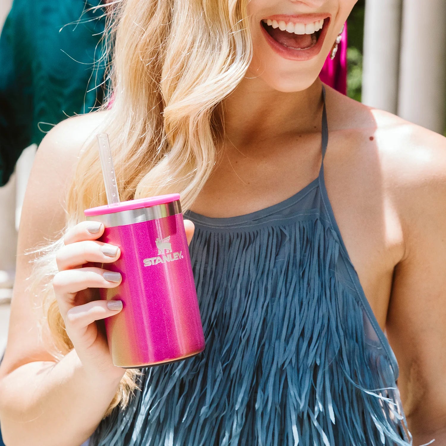 Can Cooler com canudo Stanley | 296ML em uso por mulher sorridente ao ar livre.