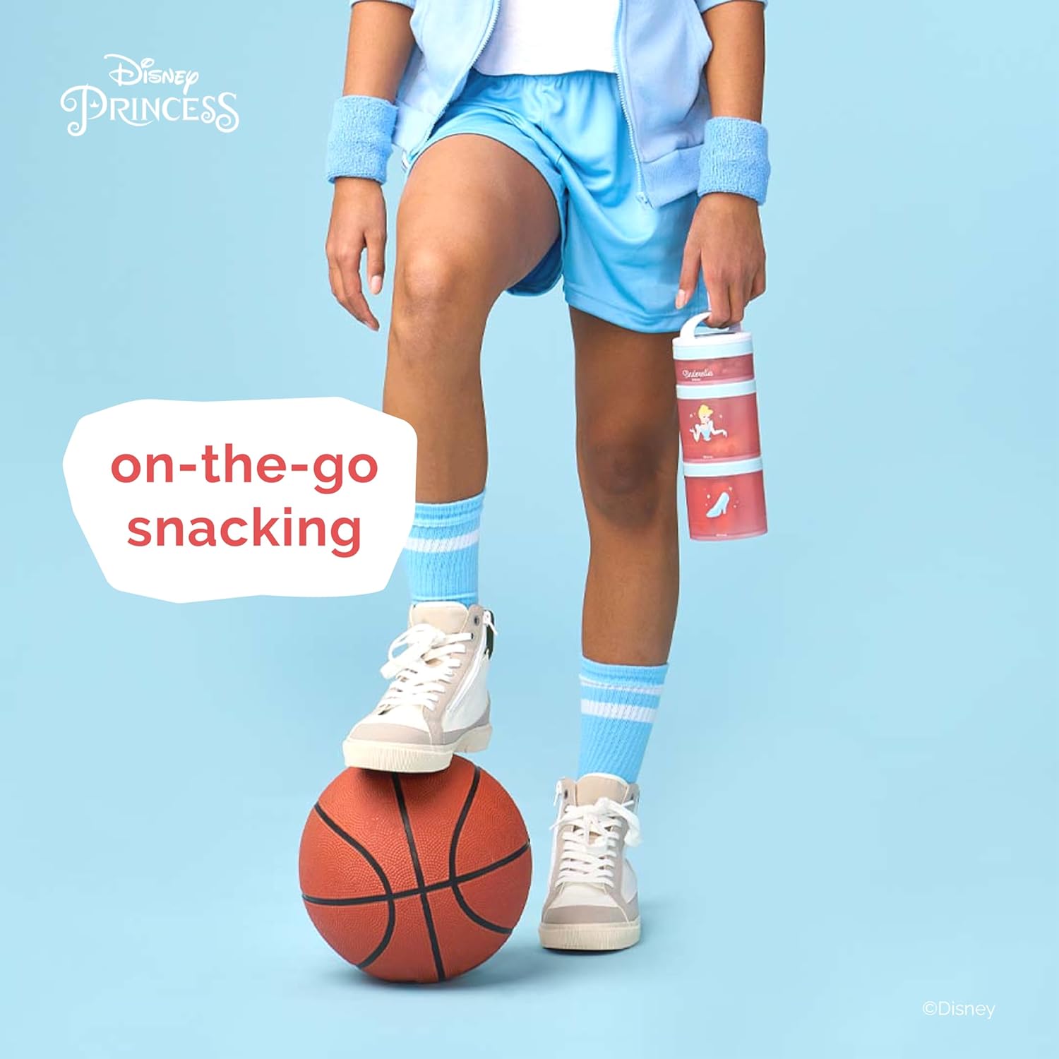 Criança com uniforme esportivo segurando garrafa Disney Princess, pronta para atividades físicas e lanches práticos on-the-go.