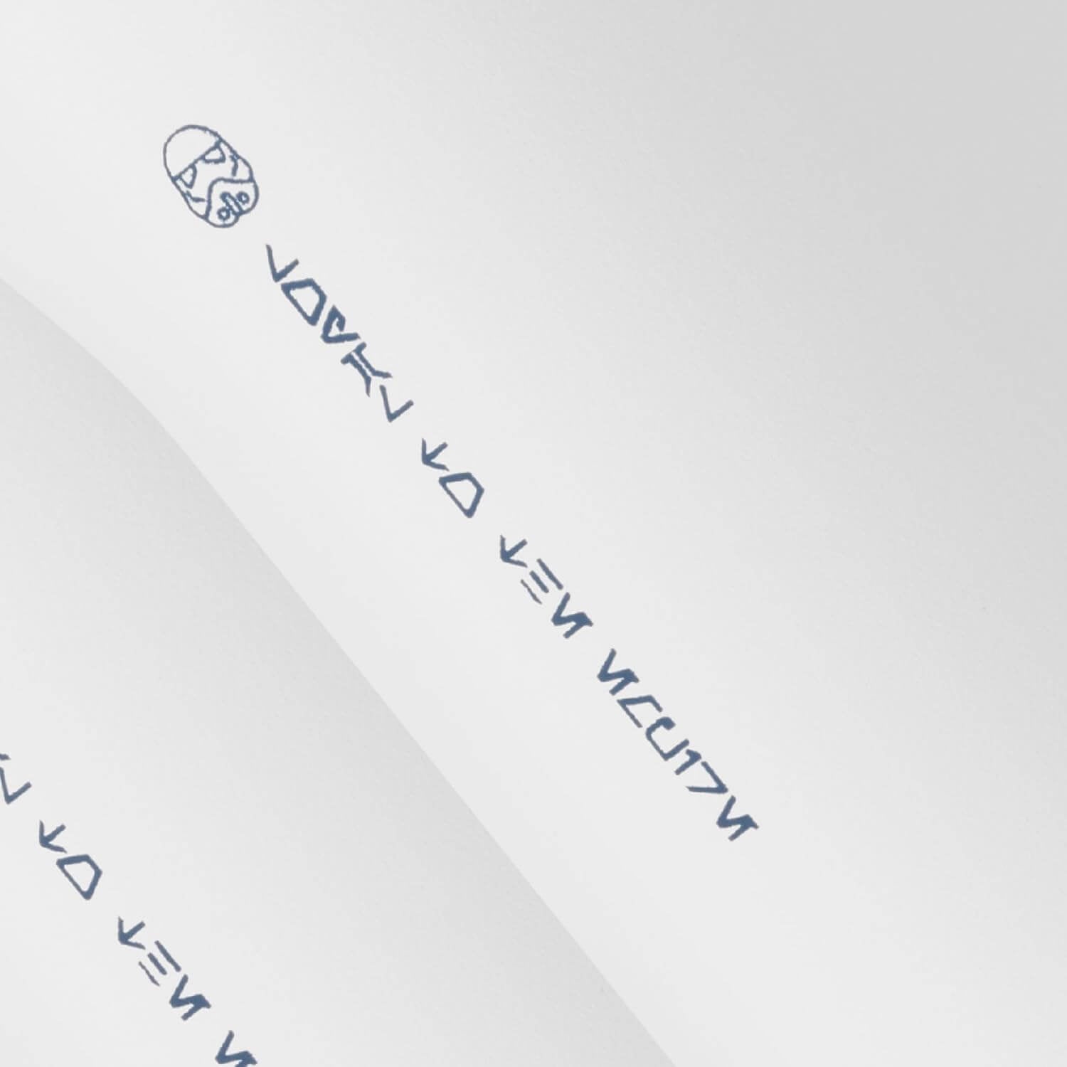Texto em alfabeto desconhecido com símbolos sobre papel branco