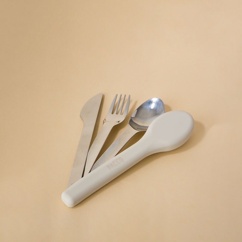 Kit de Talheres Pacco PocketSet em aço inoxidável com estojo de silicone sobre fundo bege.
