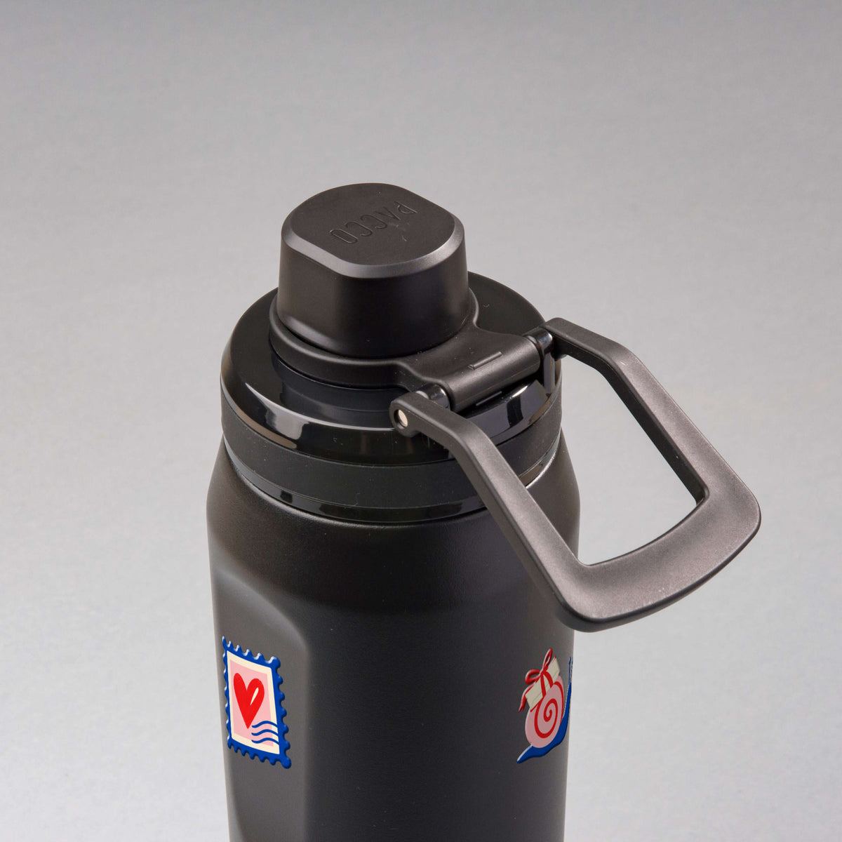 Garrafa Térmica PACCO Vyta 650ml Clube das Cartas Preta, vista de cima com a alça de lado