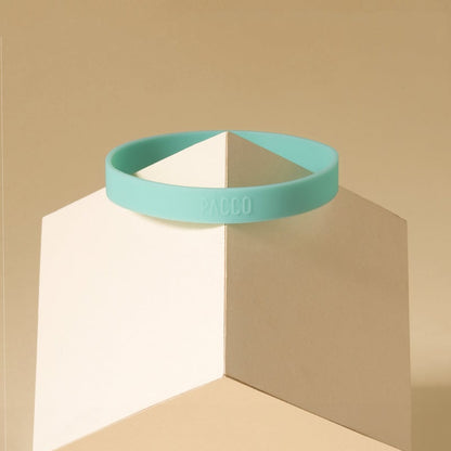 Anel de Silicone PACCO em suporte geométrico, destacando sua cor vibrante e design ergonômico para garrafas.