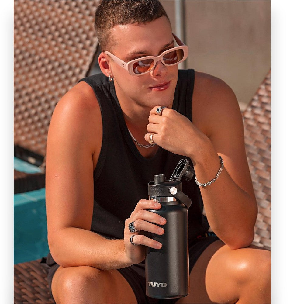 Pessoa usando Tampa com bocal - TUYO em uma garrafa preta, destacando o design esportivo e funcionalidade hermética.