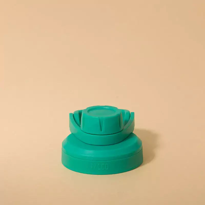 Tampa PACCO Stiff em polipropileno com vedação de silicone para fechamento hermético e seguro, verde, em fundo bege.