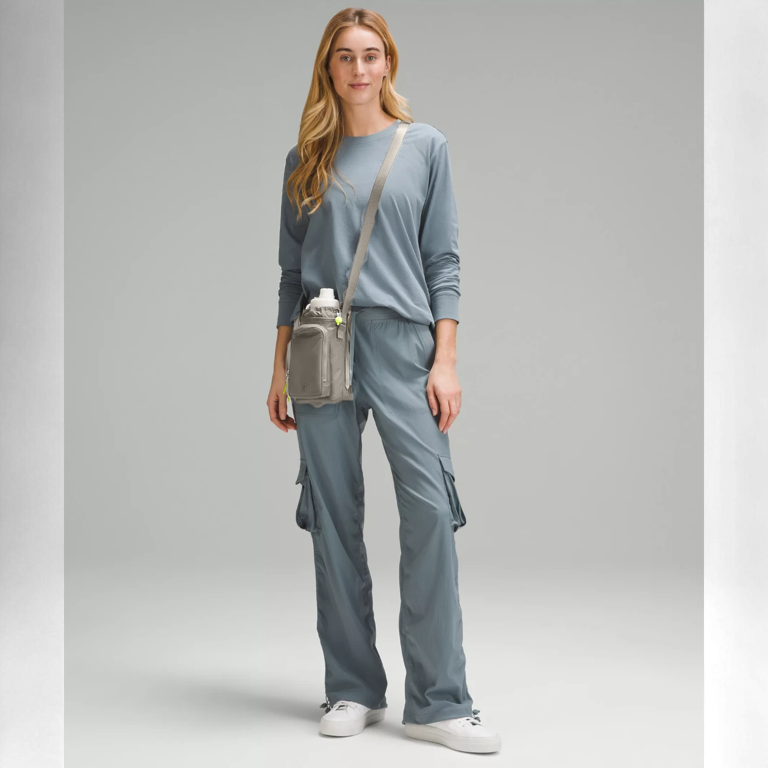 Bolsa para Garrafa Térmica - Cross Bottle Lululemon em modelo vestindo conjunto azul, destacando mobilidade e praticidade.