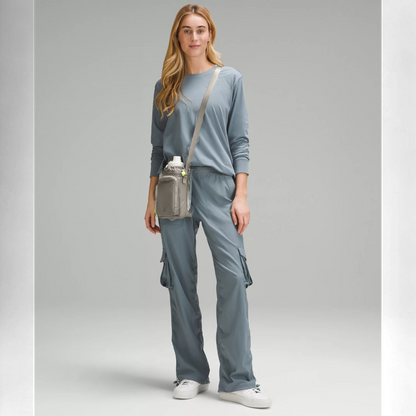Bolsa para Garrafa Térmica - Cross Bottle Lululemon em modelo vestindo conjunto azul, destacando mobilidade e praticidade.