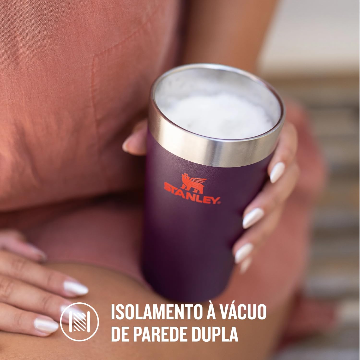 Mulher segurando Copo Térmico de Cerveja Stanley - 473ml com isolamento à vácuo de parede dupla, mantendo bebida gelada.
