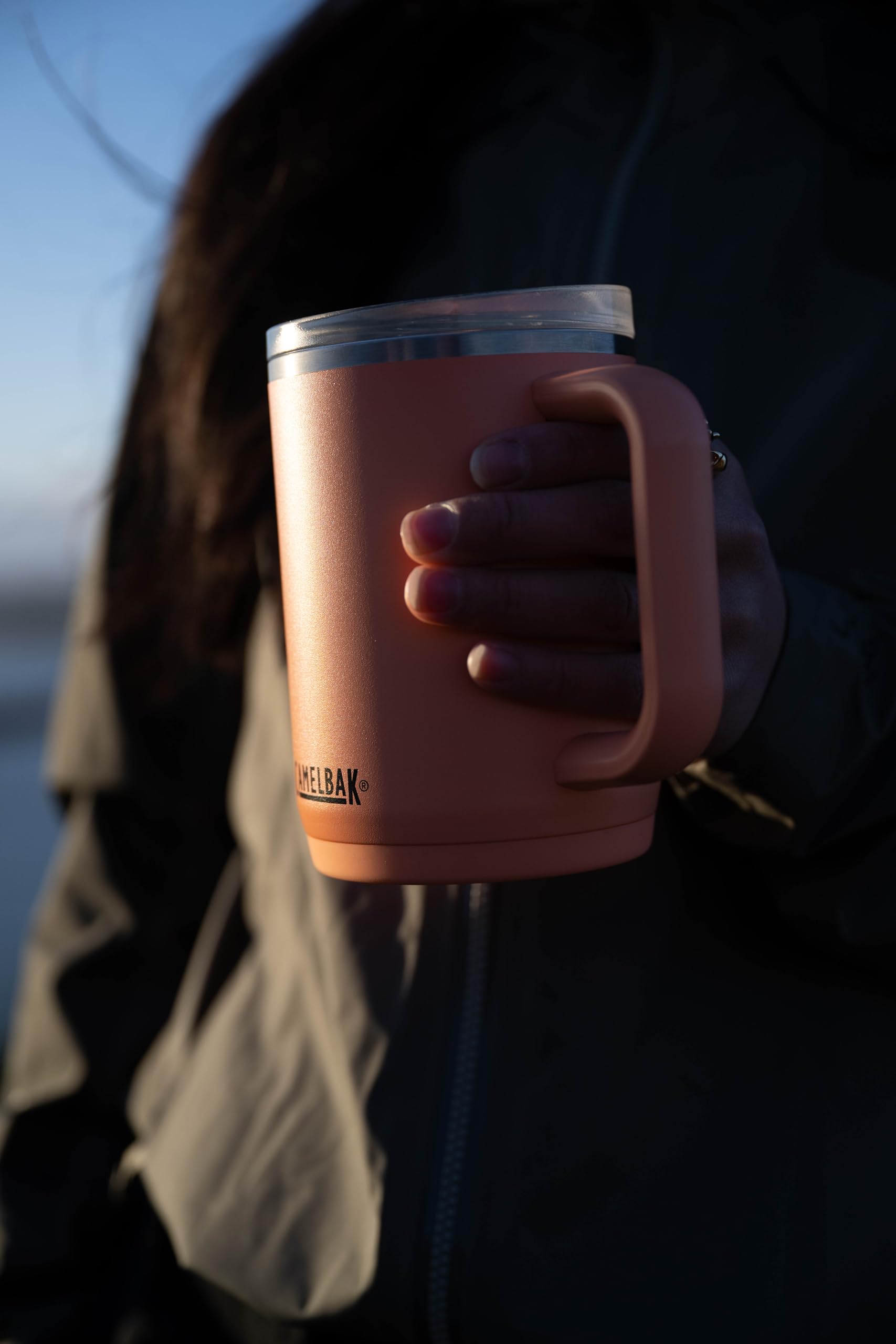 Pessoa segurando a Caneca Térmica Thrive Camelbak 470ml ao ar livre.