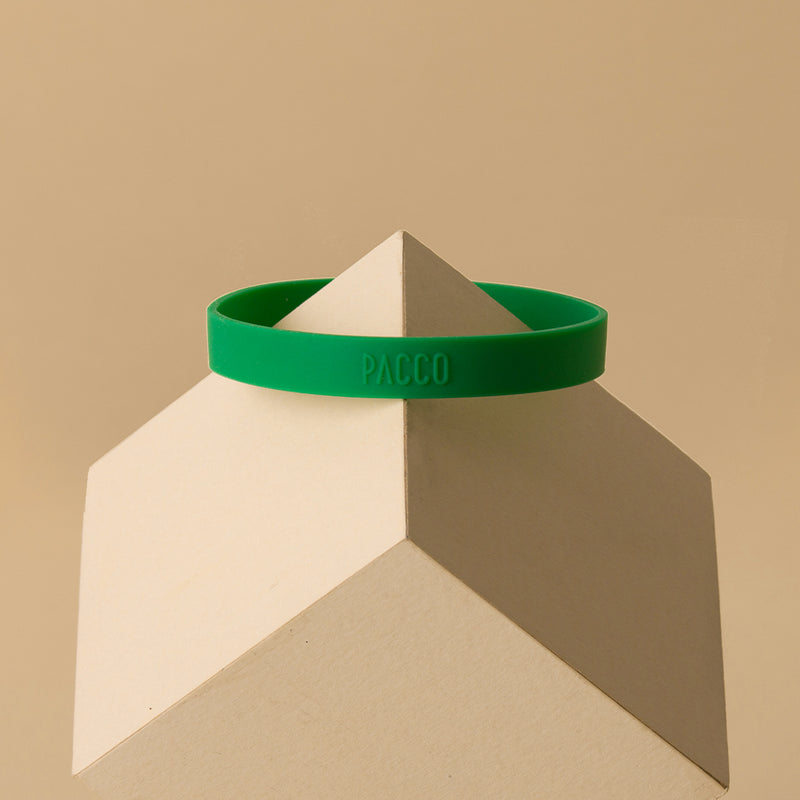 Anel de Silicone PACCO verde em pedestal geométrico, destacando design ergonômico e estilo moderno.