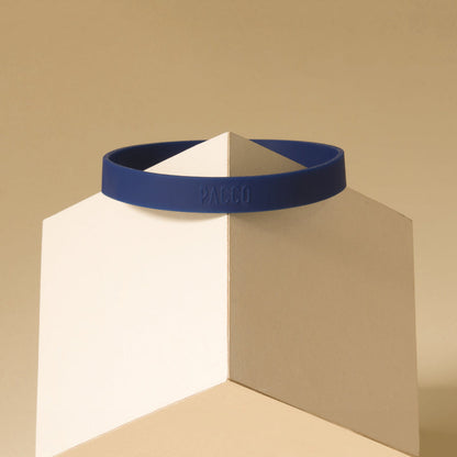 Anel de Silicone PACCO azul em exibição sobre um pedestal geométrico, destacando seu design ergonômico e toque de estilo.