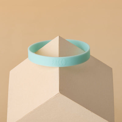 Anel de Silicone PACCO verde em cima de um suporte, destacando ergonomia e estilo no design moderno.