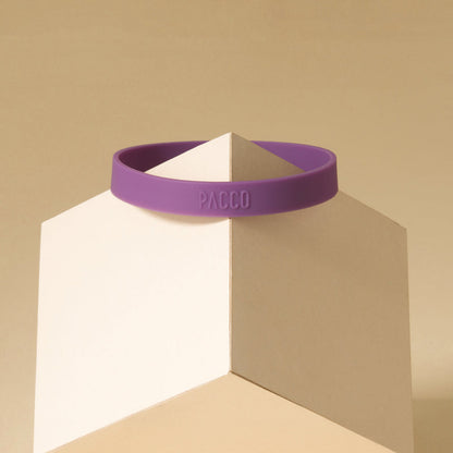 Anel de Silicone PACCO roxo, ergonômico, para estilo e conforto ao abrir garrafas, em exibição sobre um cubo branco.