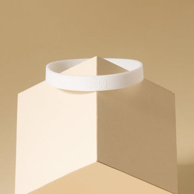 Anel de Silicone PACCO branco, estilo ergonômico, em um fundo bege, destacando design e funcionalidade.