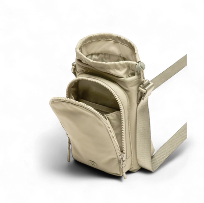 Bolsa para Garrafa Térmica - Cross Bottle Lululemon em beige, com compartimentos abertos, mostrando espaço para garrafa e itens pessoais.