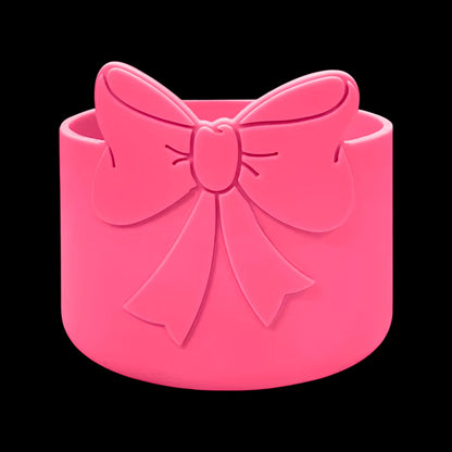 Capa de Silicone Médio - Variados 3D rosa com laço decorativo, ideal para proteção e estilo de copos e garrafas entre 350 ml e 750 ml.