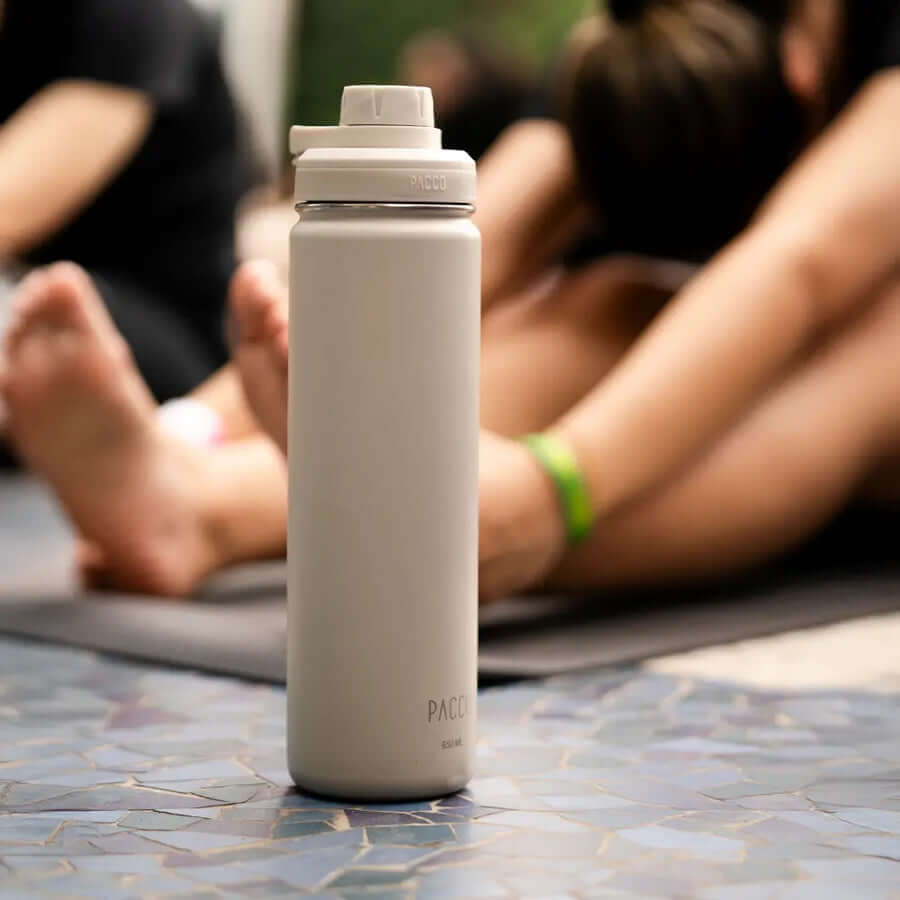 Garrafa Térmica PACCO Hydrav2 650ml em ambiente de yoga, destacando design sofisticado e alto desempenho térmico para bebidas.