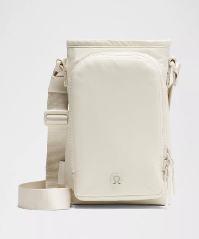 Bolsa para Garrafa Térmica - Cross Bottle Lululemon em creme vista frontal, ideal para mobilidade e praticidade no transporte diário.