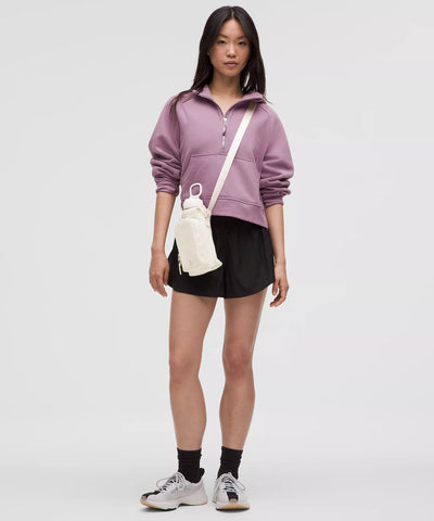 Mulher usando Bolsa para Garrafa Térmica - Cross Bottle Lululemon em caminhada urbana com design leve, espaço para itens essenciais.