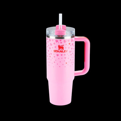 Copo Quencher Stanley 887ml rosa com alça e tampa de três posições sobre fundo preto, ideal para hidratação moderna.