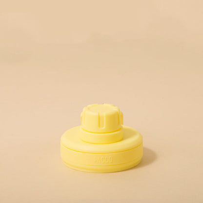 Tampa PACCO Original amarela com design moderno e alça de transporte, feita em polipropileno premium, destacada em fundo neutro.