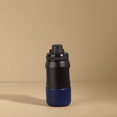 Capa vyta PACCO 350ml em silicone preto com seção inferior azul, proteção ideal para garrafas, resistente e elegante.