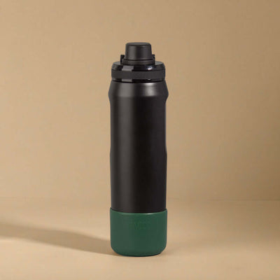 Capa Vyta PACCO 650ml em preto com base verde, proteção em silicone para garrafas, estilo e sustentabilidade.