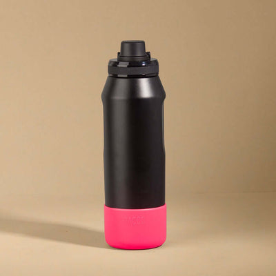 Capa Vyta PACCO 950ml em silicone preto com base rosa vibrante, proteção premium para garrafa com design moderno e sofisticado.