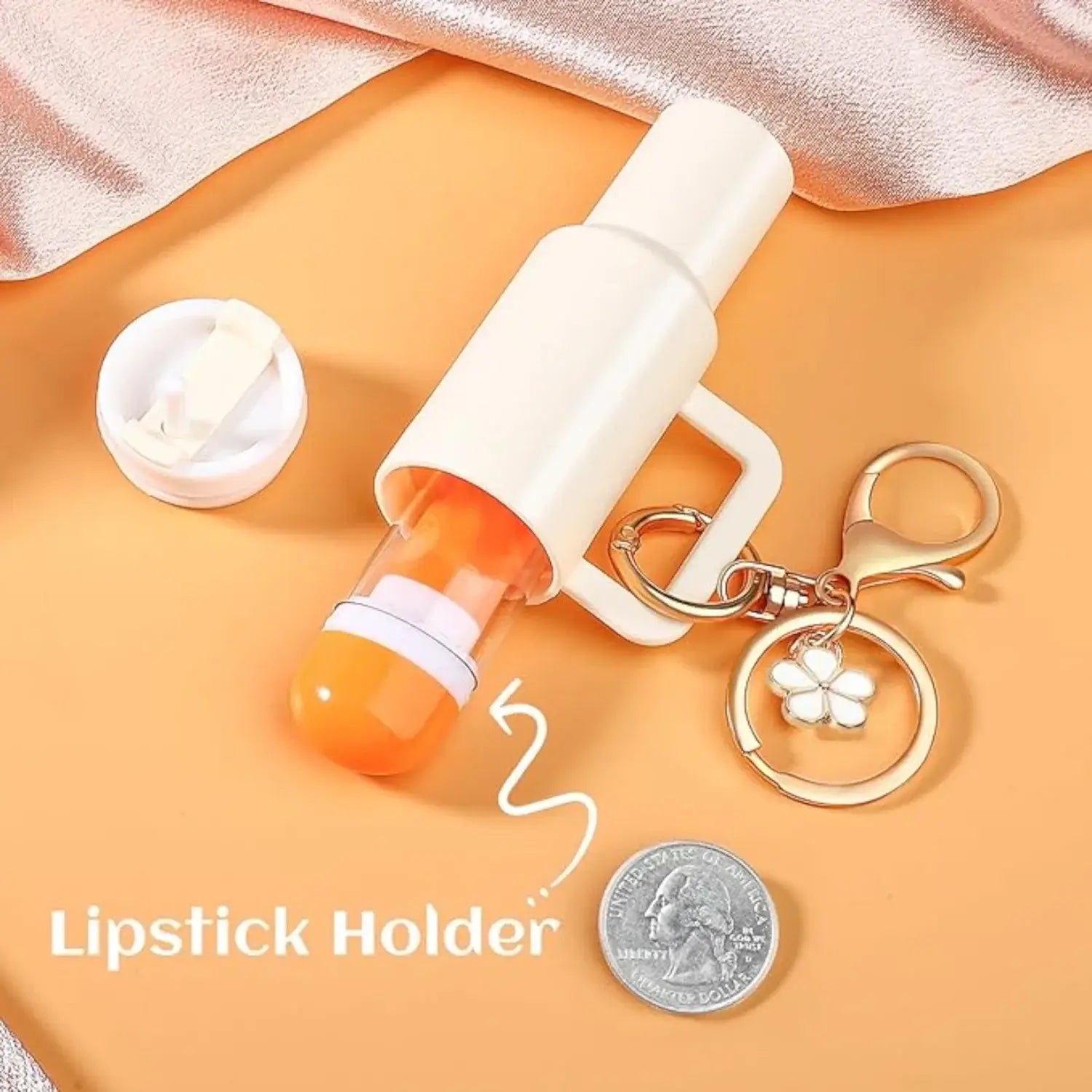 Portable lipstick holder with keychain featuring a charm and a coin for size comparison.