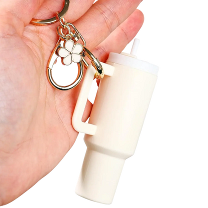 Chaveiro Copo Stanley Quencher bege com chaveiro de flor, acessório elegante para fãs dos copos Stanley.