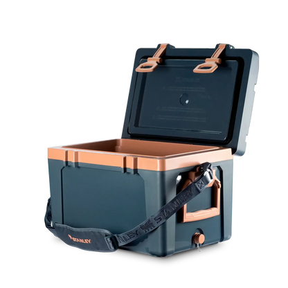 Cooler Térmico Stanley 23.7L azul com tampa aberta e alça acolchoada para transporte, ideal para aventuras ao ar livre.