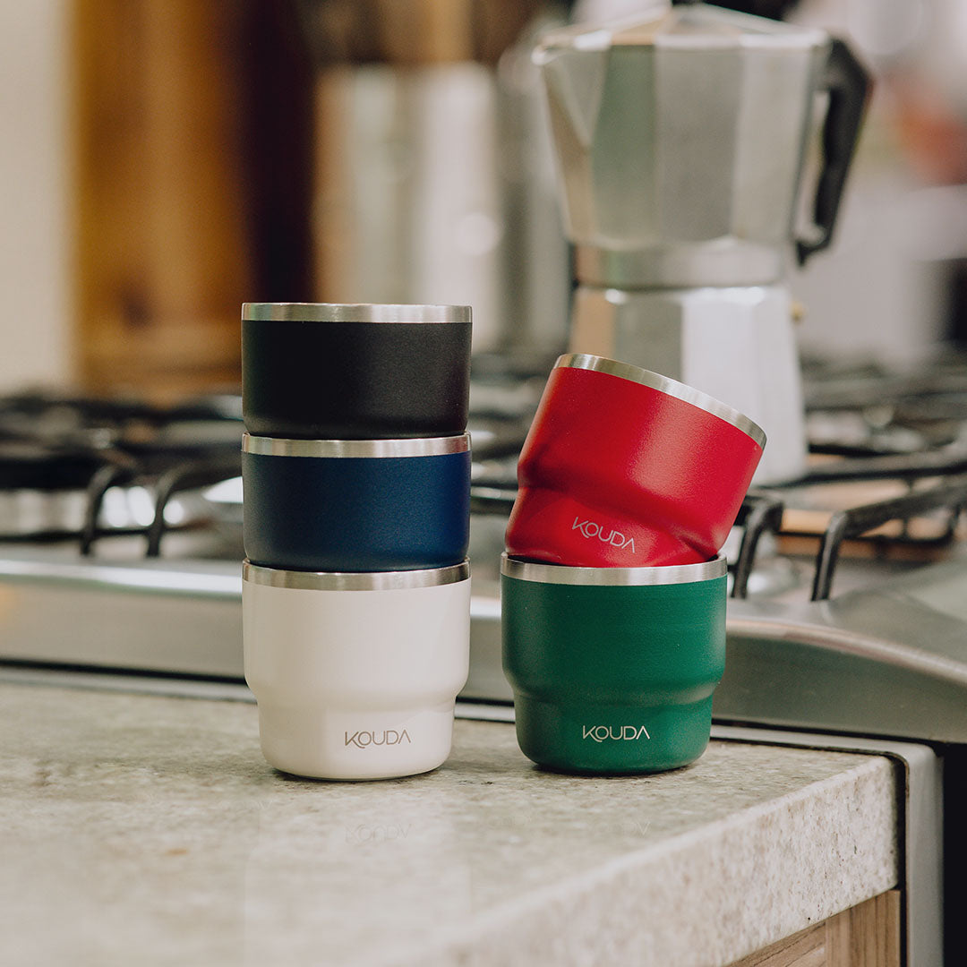 Copo Térmico Kouda Egeu 150ml in various colors on a kitchen counter.
