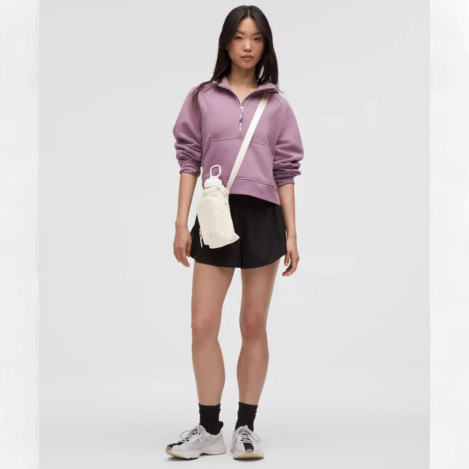 Mulher usando Bolsa para Garrafa Térmica - Cross Bottle Lululemon em passeio urbano, combinada com roupa casual esportiva.