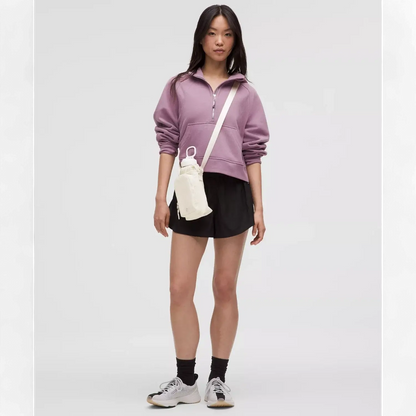 Mulher usando Bolsa para Garrafa Térmica - Cross Bottle Lululemon em passeio urbano, combinada com roupa casual esportiva.