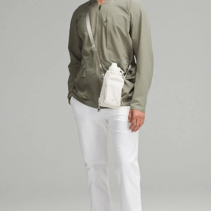 Bolsa para Garrafa Térmica - Cross Bottle Lululemon, estilo crossbody, usada por pessoa com roupa casual verde e branca.