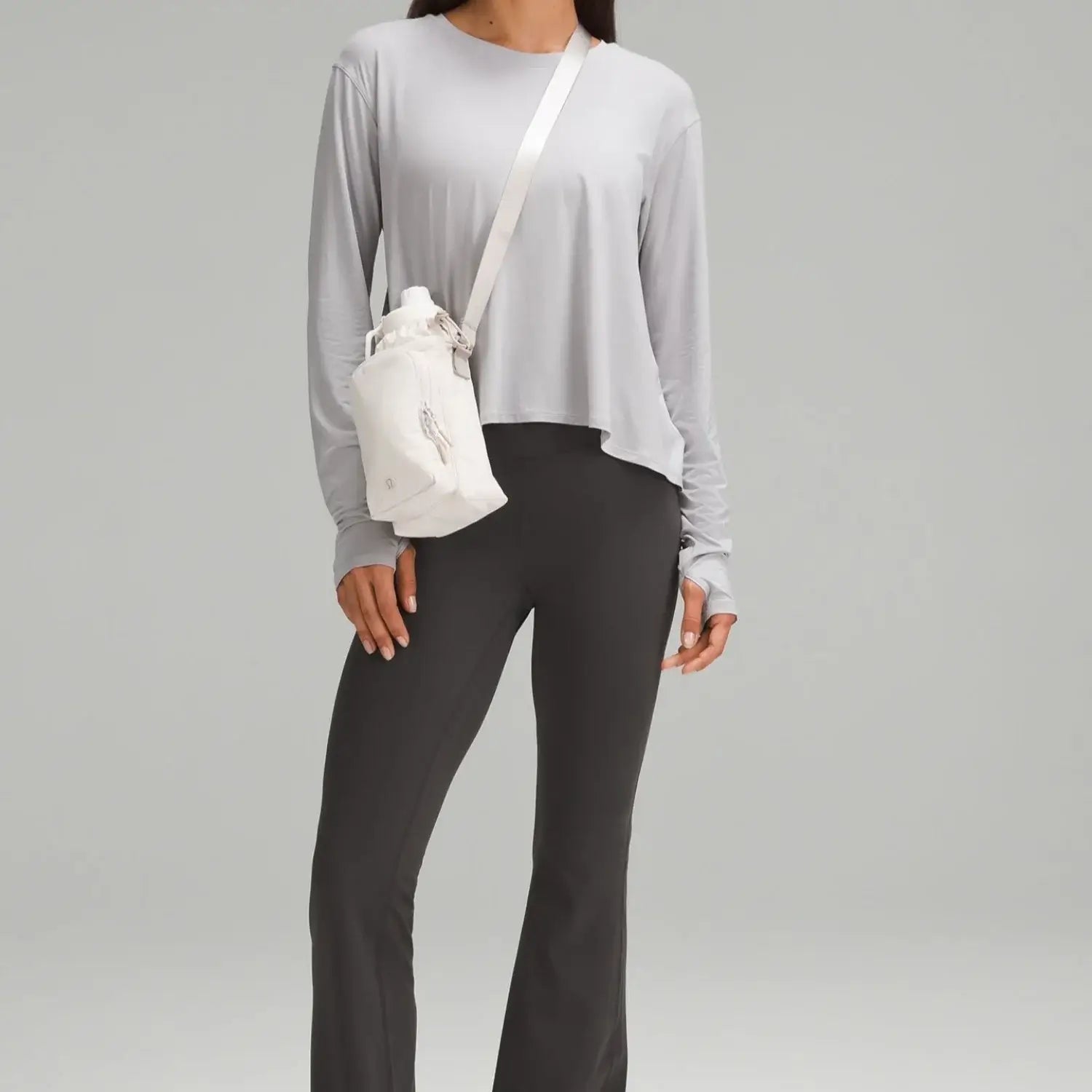 Mulher usando Bolsa para Garrafa Térmica - Cross Bottle Lululemon, leve e prática, ideal para garrafas até 1,2L e pequenos objetos.