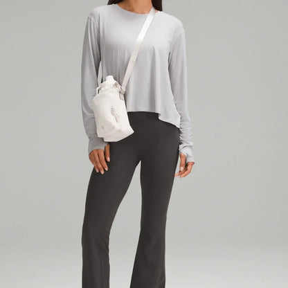 Mulher usando Bolsa para Garrafa Térmica - Cross Bottle Lululemon, leve e prática, ideal para garrafas até 1,2L e pequenos objetos.