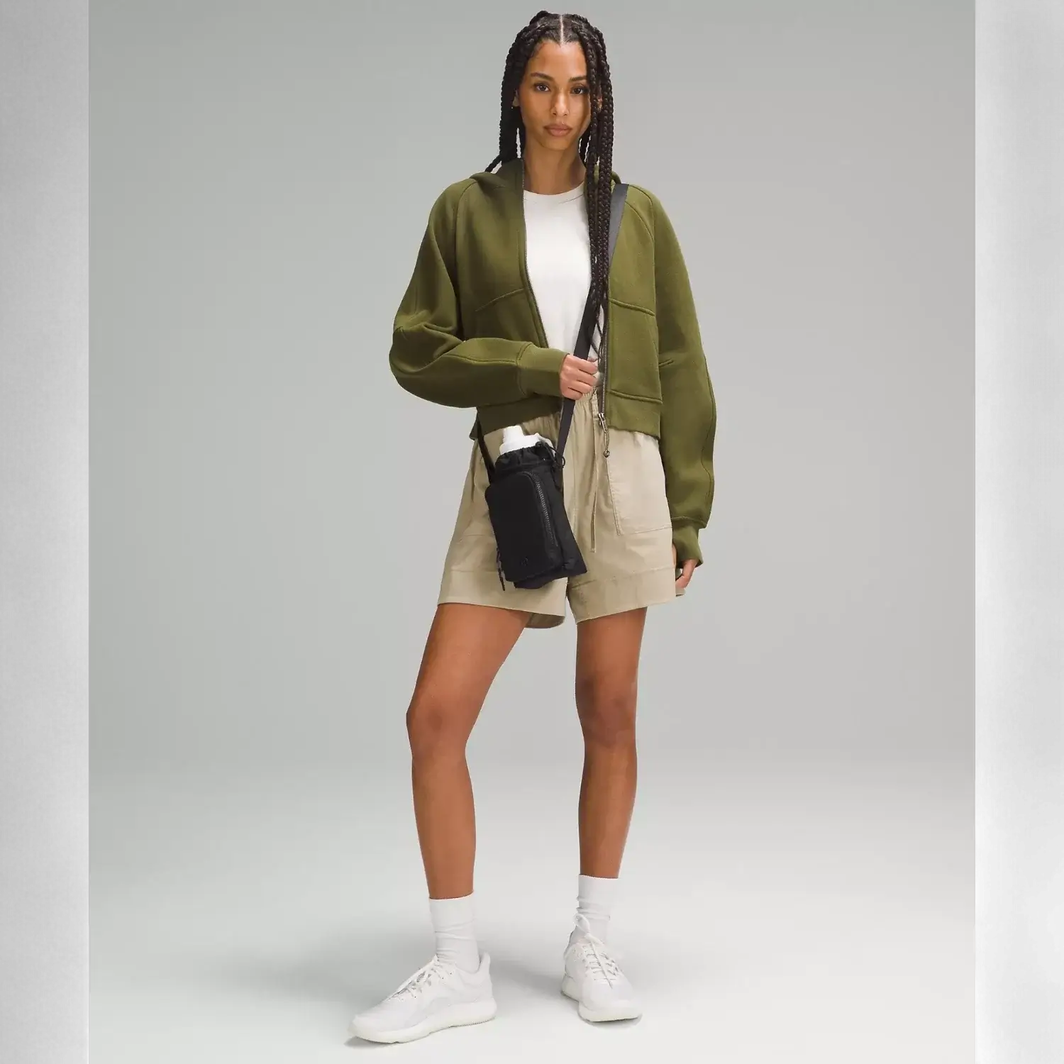 Mulher usando Bolsa para Garrafa Térmica - Cross Bottle Lululemon, verde, ideal para garrafas de até 1,2 L, prática para uso diário.