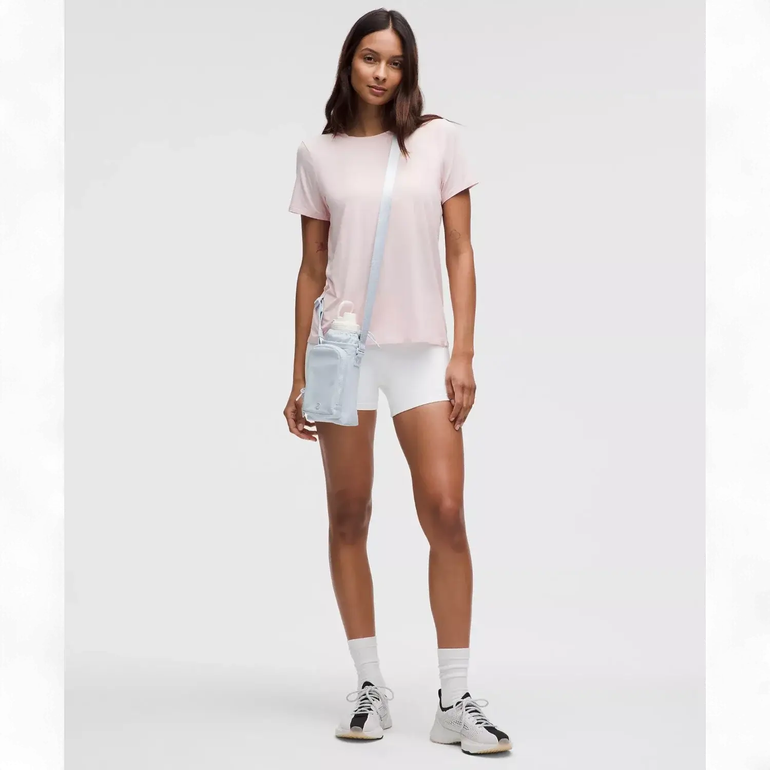 Modelo usando a Bolsa para Garrafa Térmica - Cross Bottle Lululemon, leve e prática para garrafas, celular e chaves.