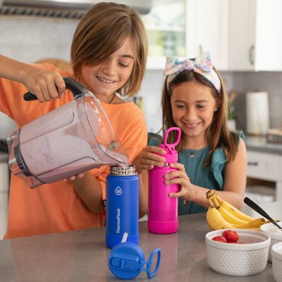 Crianças usando Garrafa Térmica Thermoflask 414ml - 16oz na cozinha, desfrutando de smoothies frescos, com frutas ao redor.