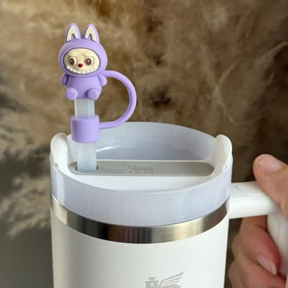 Protetor de Canudo Quencher - Variados em silicone com design criativo na cor lilás em um copo branco.